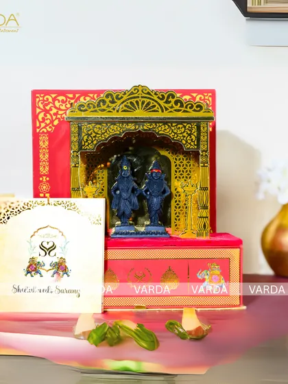 A divine wedding invitation featuring a 3D temple arch with idols of Shri Vitthal and Rukmini. The red and gold box is adorned with floral motifs and comes with a personalized invitation card, perfect for a traditional Maharashtrian wedding.