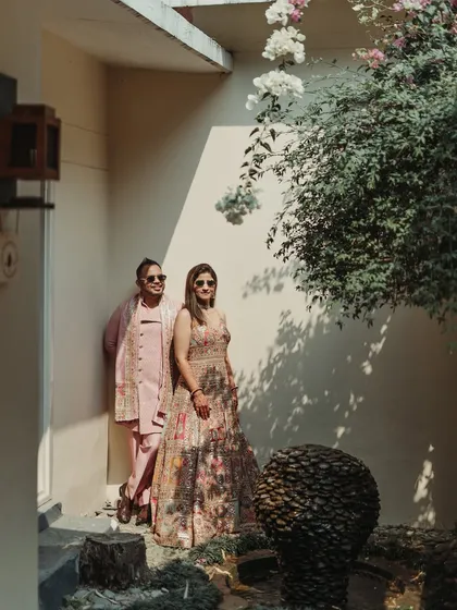 A cool and stylish portrait of the couple, posing with sunglasses in a beautifully lit corner of the venue.