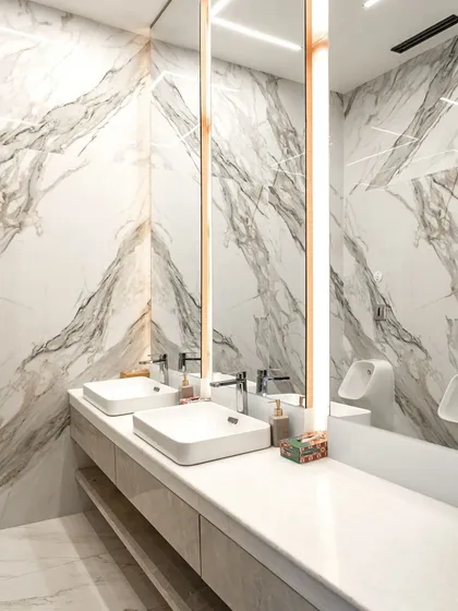 In this executive office bathroom, the focus is on material excellence. I selected slabs of Satvario Gold stone and used a book-matching technique to create a continuous, dramatic pattern across the walls, turning a functional space into a work of art.
