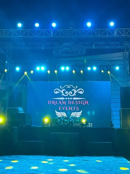A clear view of a DJ stage I set up for an outdoor wedding reception. The large LED screen displays our custom event logo, flanked by powerful speakers and lighting towers to ensure the music and visuals reach every guest.