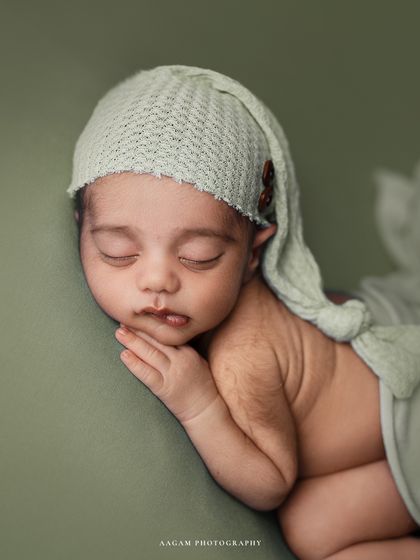 This little pistachio is sleeping so soundly. The side-lying pose, combined with a cute, soft hat, makes for an irresistibly sweet portrait.
