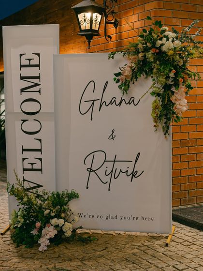 An elegant welcome sign for the Sangeet night, featuring modern calligraphy and beautiful floral arrangements.