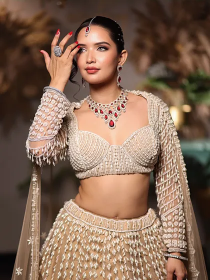 This candid-style shot captures the radiant glow of the makeup and the intricate beadwork of the outfit, showcasing a complete and polished look.