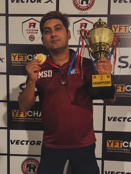 Another one for the cabinet. Our director proudly displays the championship trophy and his winner's medal after a successful campaign.