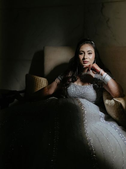 A dramatic bridal portrait of Rashmi. The use of shadow and a single light source creates a moody, painterly effect, highlighting her in her stunning reception gown.