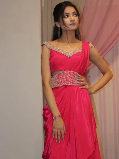 A closer look at the pink draped saree, showing the embellished belt and the draped neckline.