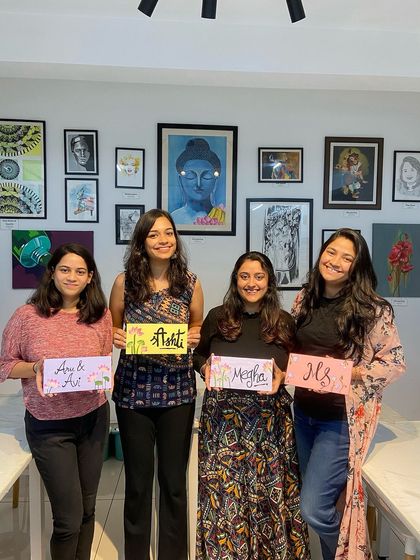 A group of friends with their custom-painted nameplates. This is a fun and practical workshop where you can create personalized decor for your home.