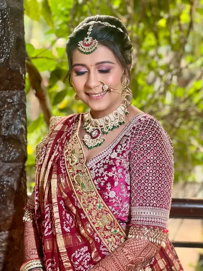 A beautiful close-up of the bride's soft glam makeup. The pink eyeshadow and radiant skin complement her traditional attire and jewelry perfectly.