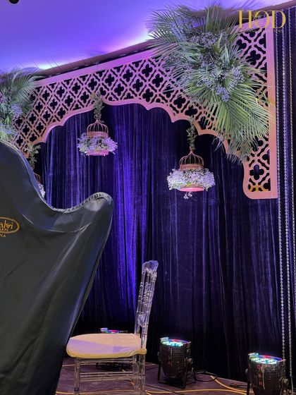 A side view of the performance stage, showing a ghost chair and the beautiful floral-filled birdcage, ready for the artists.