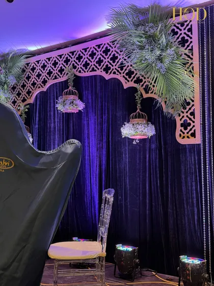 A side view of the performance stage, showing a ghost chair and the beautiful floral-filled birdcage, ready for the artists.