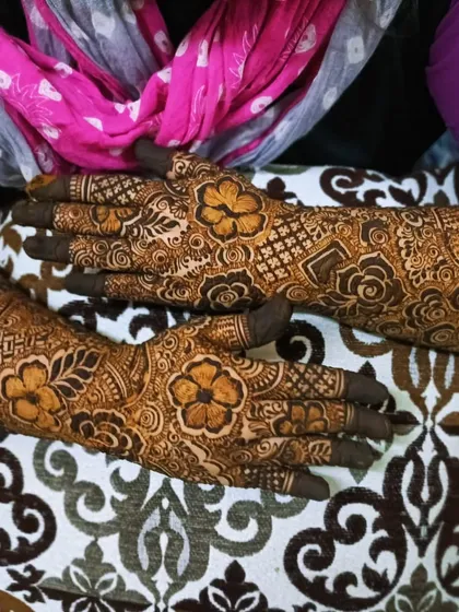 A closer look at a bridal design with personalized names 'Aleem' and 'SA' on the palms.