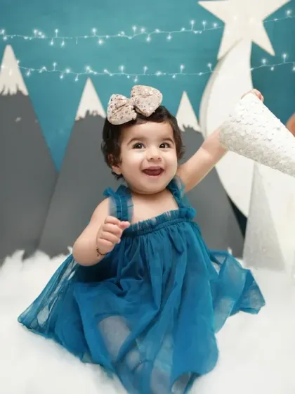 A happy toddler plays in our winter wonderland setup, complete with mountains, snow, and a teddy bear. Themed shoots are a great way to mark a seasonal birthday.