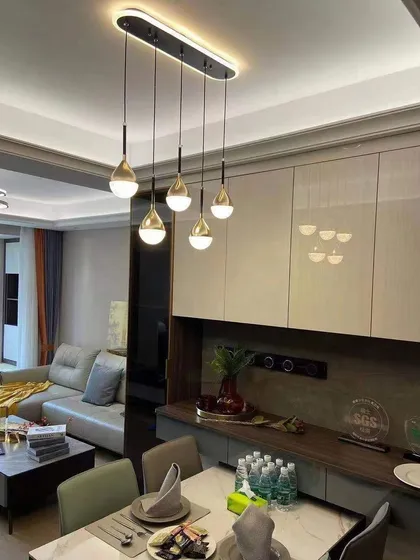 A cluster of teardrop pendants installed over a dining table. This setup provides excellent task lighting with a sleek, modern look.