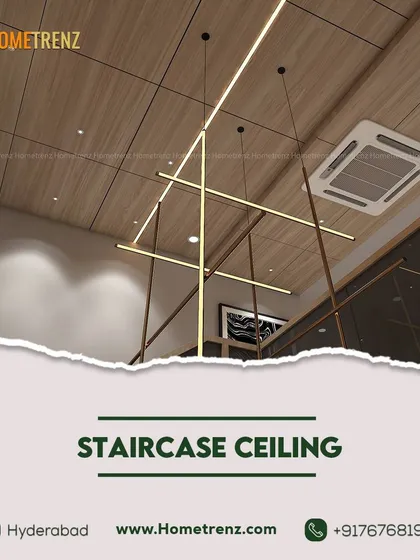 Reaching new heights. The ceiling above this staircase features a modern, linear chandelier set against a wooden panel, turning a transitional space into a design moment.