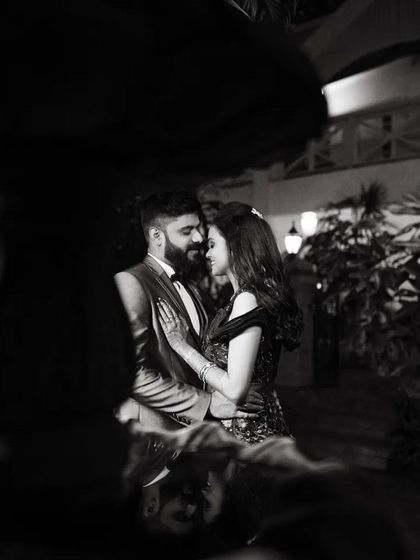 A duplicate of image 87, a romantic black and white photo of a couple at night, framed by a fountain.