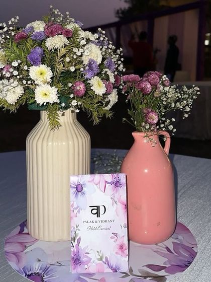 A close-up of the personalized table setting for a Haldi carnival, featuring a custom card for the couple, Palak and Vidhant.