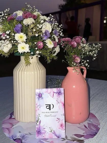A close-up of the personalized table setting for a Haldi carnival, featuring a custom card for the couple, Palak and Vidhant.