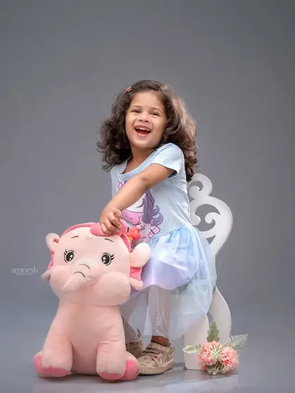 A burst of pure laughter during a fourth birthday photoshoot. This little girl shares a happy moment with her stuffed animal, showcasing the fun and relaxed atmosphere of my studio.