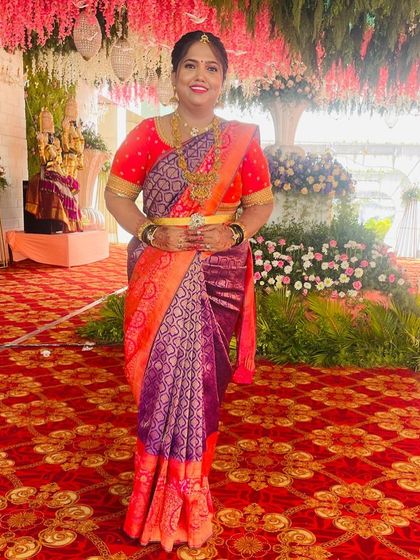 A vibrant, multi-colored Kanchivaram saree in shades of orange and purple, paired with a simple red blouse to balance the look.