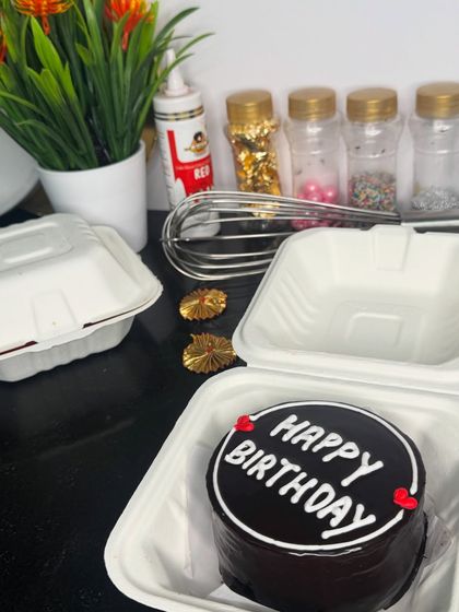 A classic chocolate bento cake with a "Happy Birthday" message. It's a simple, elegant, and delicious choice for a small and personal celebration.