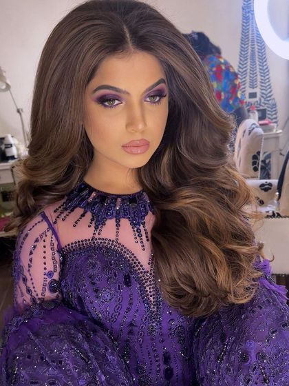 A close-up capturing the bride's stunning makeup and the flawless finish of her soft curls.