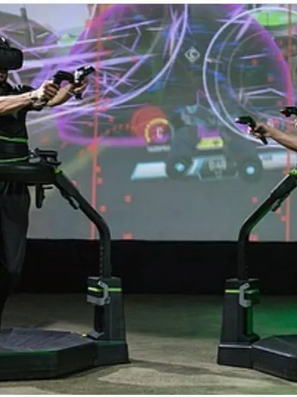 A front-facing view of the Virtuix Omni team-building activity, highlighting the intense focus and engagement of the participants.
