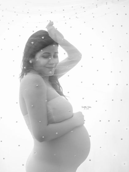 A portrait of serene beauty. The delicate, pearl-studded veil softens the image, creating a gentle and dreamy portrait that focuses on the mother's peaceful expression.