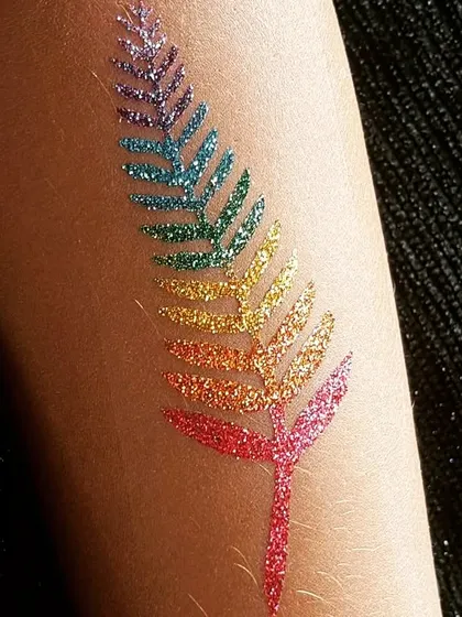 A beautiful leaf design created with a full spectrum of rainbow glitter. This is a colorful and artistic choice.