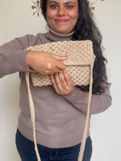 A beautiful beige macrame sling bag. The braided strap is both comfortable and stylish, making it a perfect everyday accessory.