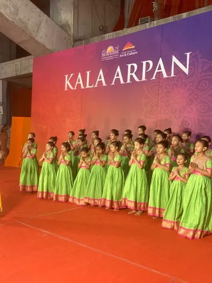 A different angle of the young performers at the Art of Living event, showing their focus as they await their cue. Moments like these are crucial for building stage presence.