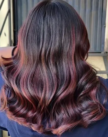 Learn to create stunning and vibrant hair transformations. Our curriculum covers the complete science of hair color, enabling you to master everything from subtle highlights to bold, expressive shades like this rich red.