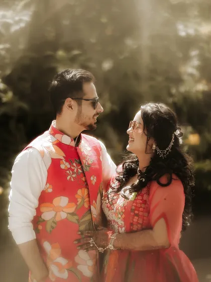 A portrait filled with light and laughter. The sun flare adds a magical glow as the couple shares a happy, candid moment, their smiles lighting up the frame.