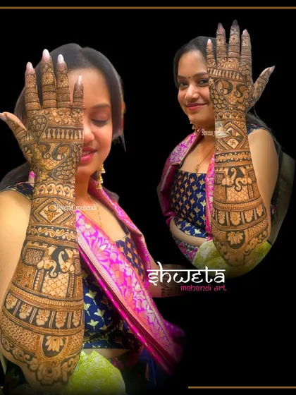 A happy client showing off her full-arm bridal mehendi. The design features a mix of traditional elements like elephants and peacocks, resulting in a rich, dark stain.