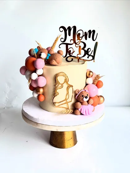 The gold line art of the expectant mother is a beautiful, modern touch on this baby shower cake.