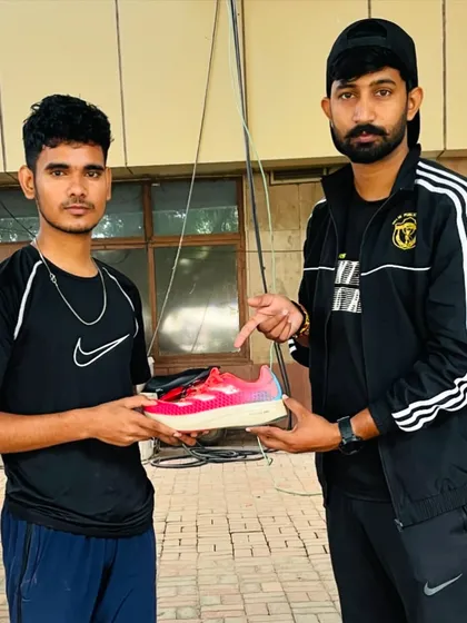 Presenting a new pair of running shoes to a young, promising athlete. I am committed to nurturing talent, no matter their background.