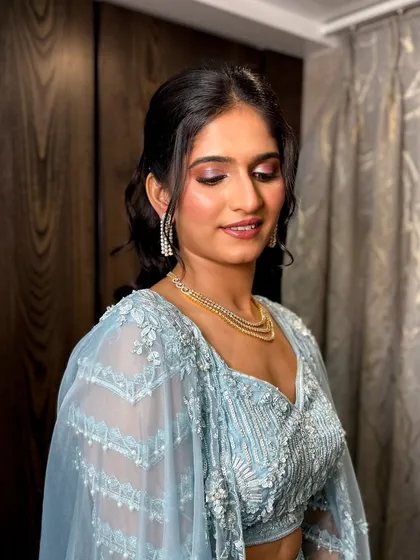 A close-up of the makeup, featuring a soft purple and pink eyeshadow blend and a natural, glossy lip.
