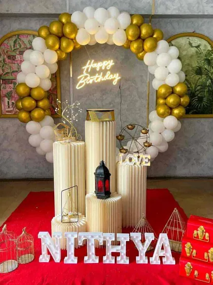 A classic white and gold balloon ring decoration, personalized with marquee letters and elegant props for a sophisticated look.