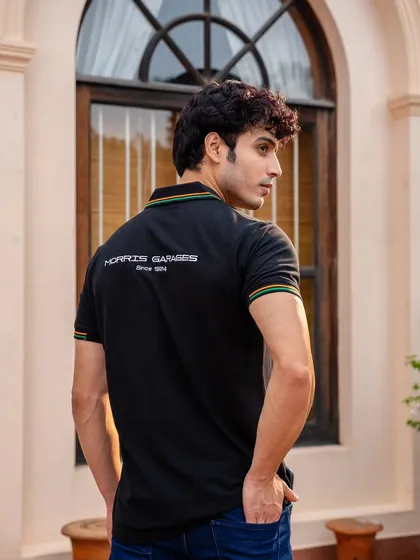 A back view of a model wearing an MG Motor polo shirt. This shot is specifically designed to showcase the branding and design details on the rear of the garment.