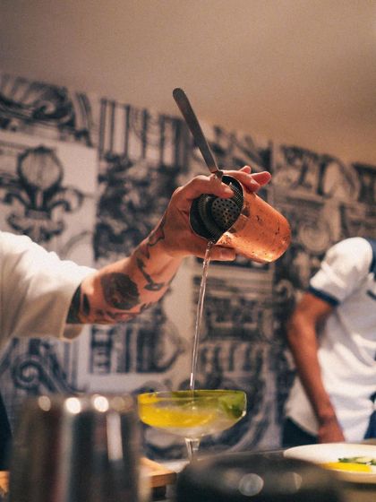 A close-up of Marco Giovani's expert pour. The precision and flair of our guest mixologists make for an unforgettable bar experience.