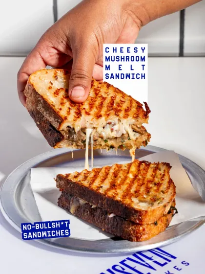 Another shot of the Cheesy Mushroom Melt, this time with a dramatic cheese pull that's sure to grab attention.
