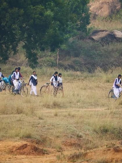 The girls bicycling through the fields to get to the boulders. This image captures their determination and the adventurous spirit we hope to foster.