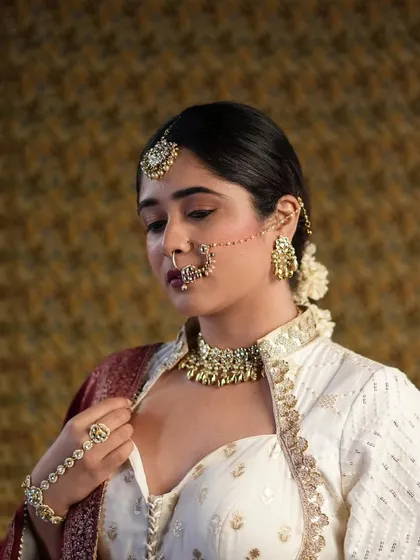 A full view of the retro-glam look. The combination of classic makeup, traditional jewelry like the nath and maang tikka, and a sleek hairstyle creates a truly memorable bridal statement.
