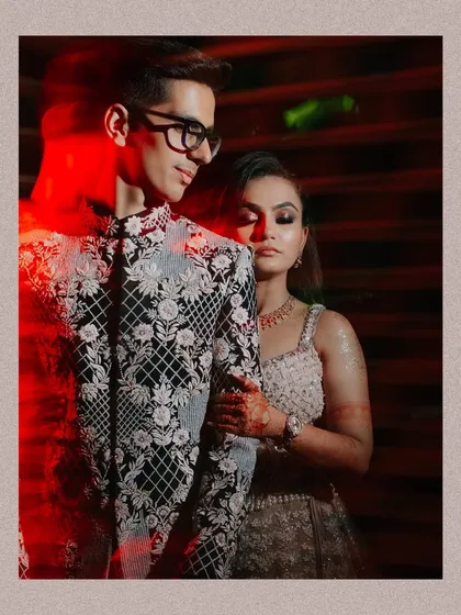 A creative portrait using a slow shutter and red light to paint streaks across the image, adding an artistic flair to the Sangeet photo.