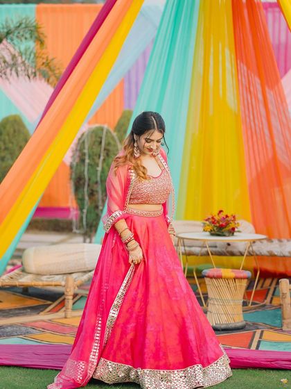 A full view of the pink lehenga, showing how I style it for a daytime wedding function. The colorful decor makes the outfit pop.
