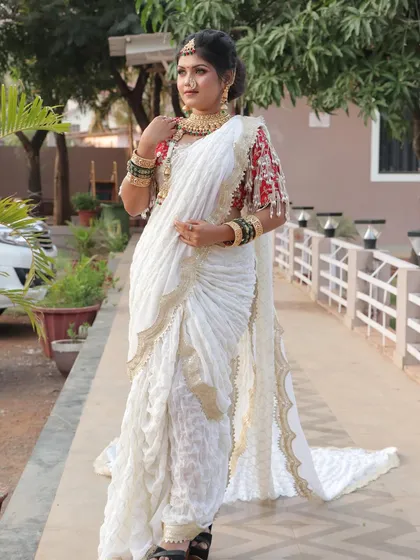 A full view of a modern Maharashtrian bridal look, featuring a white saree with a long, elegant train. This is a unique take on traditional attire, perfect for a bride who wants to blend tradition with contemporary style.