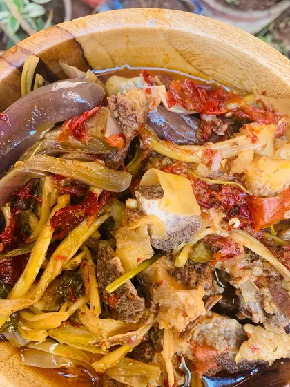 A close-up of the beef bone soup, showing all the different vegetables and herbs.
