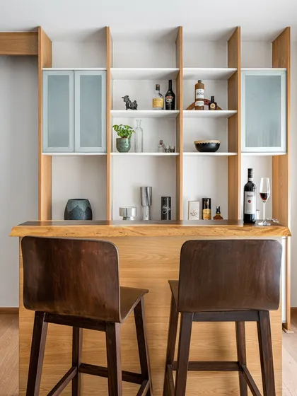 A closer view of the 'Pepper and Coffee' bar unit, highlighting the natural wood grain of the counter and the elegant open shelving for glassware and bottles.