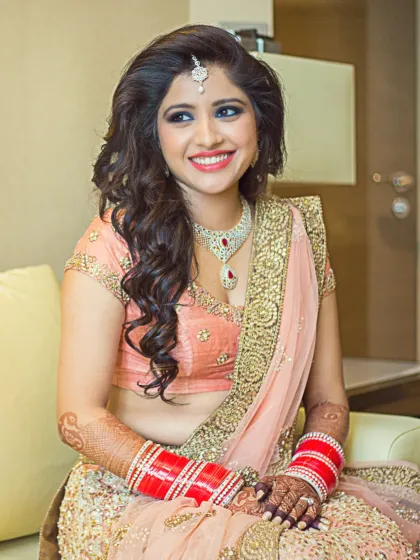 A beautiful portrait of a bride, smiling as she gets ready. The soft lighting and her relaxed expression capture a moment of happy anticipation.