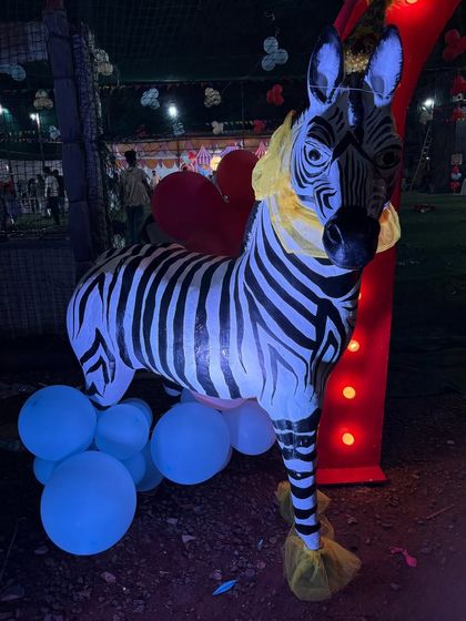 A life-sized zebra prop with a festive yellow collar, one of the many detailed elements that made the carnival theme so immersive.