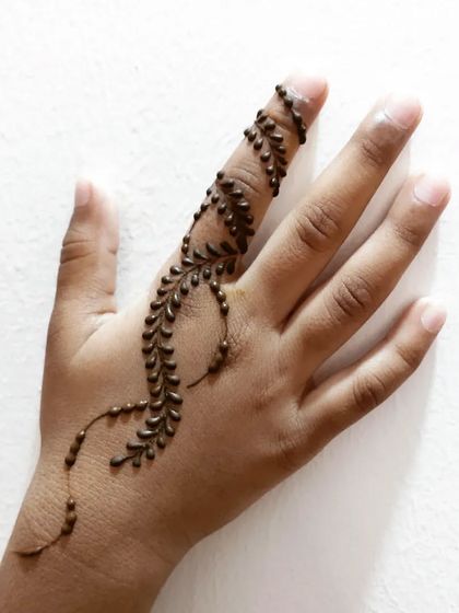 A simple leafy vine design on a child's finger and hand.